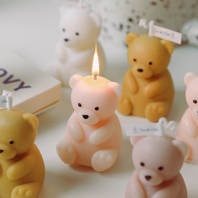 誕生日は装飾のかぎつけられるハンドメイドのテディー・ベアの形づけられた蝋燭を手作りする