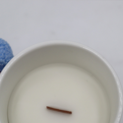 香りの感覚は木製の灯心が付いている白い陶磁器の蝋燭をかぎつけた